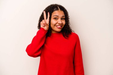 Beyaz arka planda izole edilmiş genç Afrikalı Amerikalı kadın iki numarayı parmaklarıyla gösteriyor..