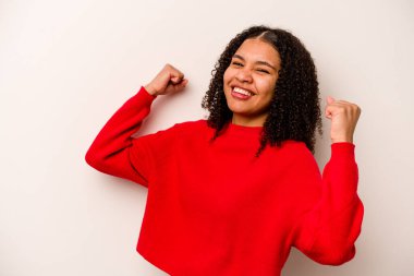 Genç Afrikalı Amerikalı kadın beyaz arka planda yalnız başına tasasız ve heyecanlı tezahüratlar yapıyor. Zafer konsepti.