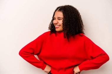 Beyaz arka planda izole edilmiş genç Afrikalı Amerikalı kadın mutlu bir şekilde gülüyor ve ellerini karnının üstünde tutarak eğleniyor..