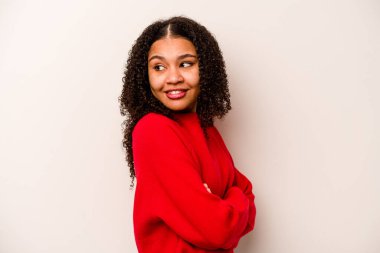 Genç Afrikalı Amerikalı kadın beyaz arka planda izole edilmiş gülüyor ve eğleniyor..