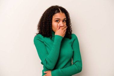 Genç Afrikalı Amerikalı kadın beyaz arka planda izole edilmiş ağzı kapalı ve elleri endişeli görünüyor..