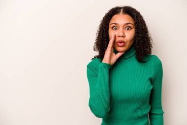 Beyaz arka planda izole edilmiş genç Afrikalı Amerikalı kadın gizli bir sıcak fren haberinin olduğunu söylüyor.