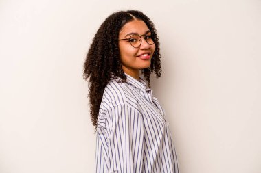 Beyaz arka planda izole edilmiş genç Afrikalı Amerikalı kadın ellerini kalçasında tutuyor..