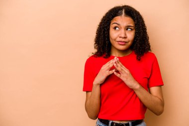 Genç Afrikalı Amerikalı kadın, bej arka planda izole edilmiş, bir fikir üretiyor..