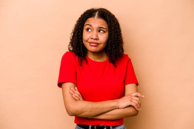 Genç Afrikalı Amerikalı kadın bej arka planda izole edilmiş hedeflerine ve amaçlarına ulaşma hayali kuruyor.