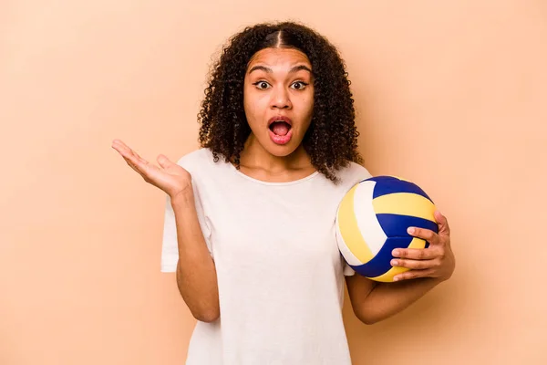 Young African American Woman Playing Volleyball Isolated Beige Background Surprised — стокове фото