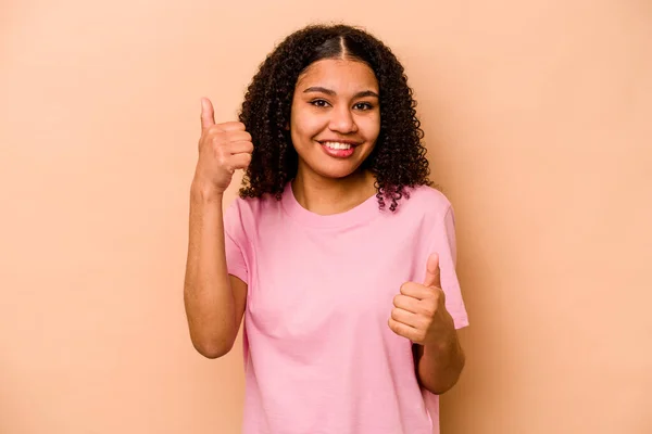若いアフリカ系アメリカ人女性はベージュの背景に孤立し 親指を上げ 笑顔で自信を持って — ストック写真
