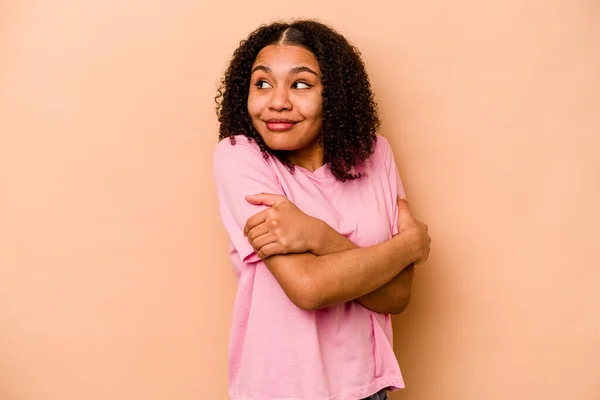 Joven Mujer Afroamericana Aislada Sobre Abrazos Fondo Beige Sonriente Despreocupada —  Fotos de Stock