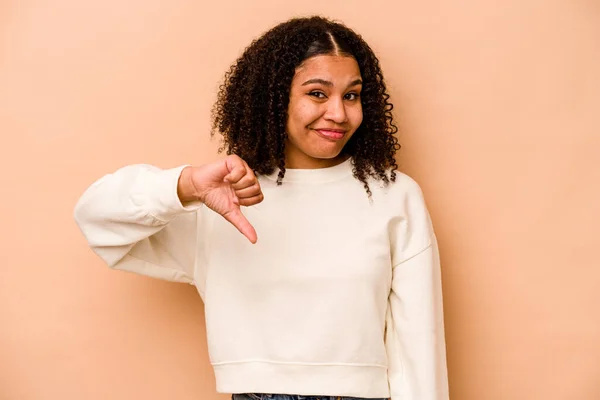 親指を示すベージュの背景に隔離された若いアフリカ系アメリカ人女性 失望の概念 — ストック写真