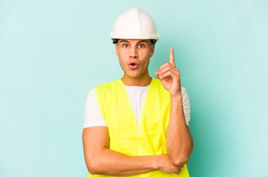 Kafkasyalı genç işçi, mavi arka planda izole edilmiş. Harika bir fikri var. Yaratıcılık kavramı..