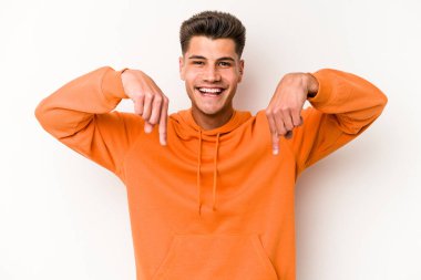 Beyaz arka planda izole edilmiş genç beyaz bir adam parmakları aşağıda, olumlu bir his var..