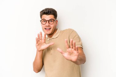 Beyaz arka planda izole genç beyaz adam yakın bir tehlike nedeniyle şoka uğruyor