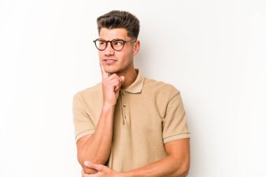 Beyaz arka planda izole edilmiş genç beyaz bir adam bir strateji planlıyor, bir iş yolu düşünüyor..