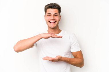 Beyaz arka planda izole edilmiş beyaz bir adam iki eliyle bir şey tutuyor..