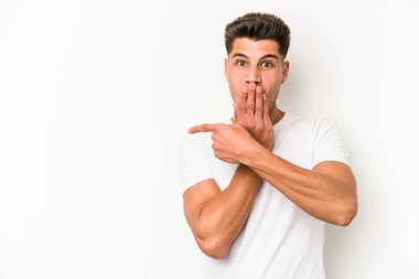 Beyaz arka planda izole edilmiş genç beyaz adam yan tarafı işaret ediyor