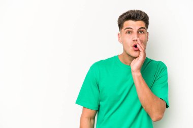 Beyaz arka planda izole edilmiş genç beyaz bir adam gizli bir sıcak fren haberi veriyor ve yana bakıyor.