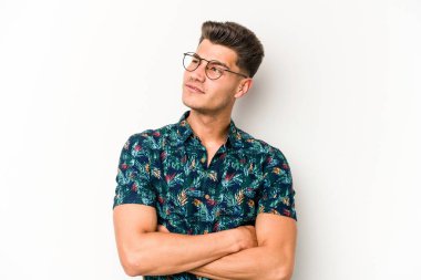 Beyaz arka planda izole edilmiş genç beyaz adam hedeflere ve amaçlara ulaşmayı hayal ediyor.