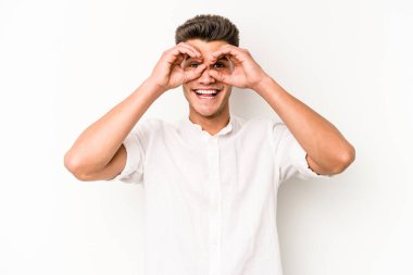 Beyaz arka planda izole edilmiş genç beyaz bir adam gözlerinde sorun olmadığını gösteriyor.