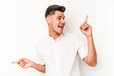 Beyaz arka planda izole edilmiş genç beyaz bir adam farklı kopya alanlarını gösteriyor, birini seçiyor, parmaklarıyla gösteriyor..