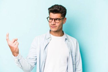 Kafkasyalı genç adam mavi arka planda izole edilmiş seni işaret ediyor sanki davet ediliyormuş gibi..