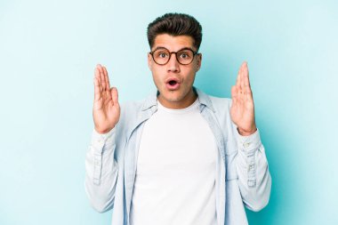 Kafkasyalı genç bir adam mavi arka planda izole edilmiş. Bir fikri, ilham verici bir fikri var..