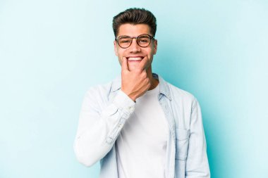 Kafkasyalı genç adam mavi arka planda izole edilmiş iki seçenek arasında şüphe duyuyor.