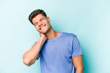 Kafkasyalı genç bir adam mavi arka planda izole edilmiş. Durağan yaşam tarzından dolayı boyun ağrısı çekiyor..