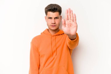 Beyaz arka planda izole edilmiş genç beyaz bir adam elini uzatmış, dur işareti göstererek seni engelliyor..
