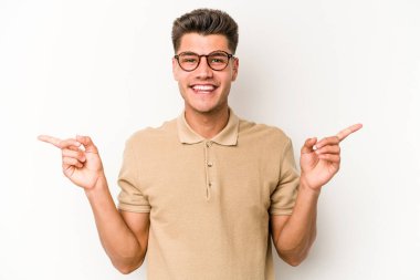 Beyaz arka planda izole edilmiş genç beyaz bir adam farklı kopya alanlarını gösteriyor, birini seçiyor, parmaklarıyla gösteriyor..