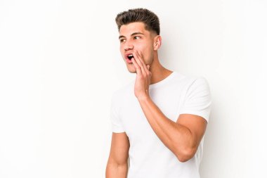 Beyaz arka planda izole edilmiş genç beyaz adam gördüğü bir şey yüzünden şoka uğruyor..