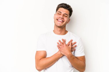 Beyaz arka planda izole edilmiş beyaz tenli genç bir adam, dostane bir ifadeye sahip, avuçlarını göğsüne bastırıyor. Aşk konsepti.