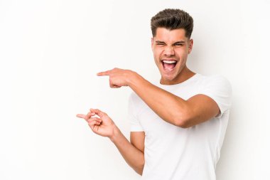 Beyaz arka planda izole edilmiş genç beyaz bir adam işaret parmağıyla işaret ettiği için heyecanlı..