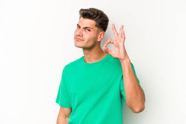 Beyaz arka planda izole edilmiş genç beyaz bir adam bir göz kırptı ve elleriyle iyi bir jest yaptı..
