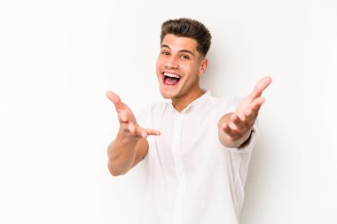 Beyaz arka planda izole edilmiş genç beyaz adam kameraya sarıldığı için kendinden emin hissediyor..