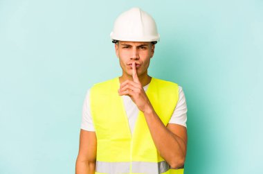 Genç beyaz adam mavi arka planda izole edilmiş bir şekilde bir sır saklıyor ya da sessizlik istiyor..