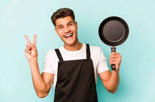 Young Caucasian Cooker Holding Frying Pan Isolated Blue Background Joyful — Foto Stock
