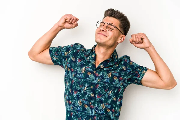 Beyaz arka planda izole edilmiş genç beyaz adam kollarını uzatıyor, rahat bir konumda..