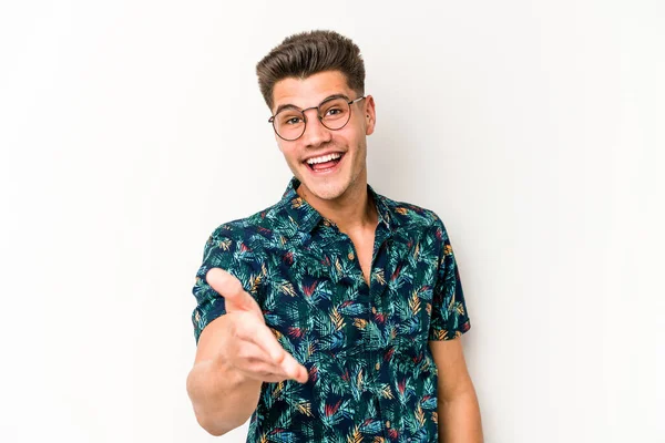 Beyaz arka planda izole edilmiş genç beyaz bir adam selamlama jesti olarak kameraya elini uzatıyor..