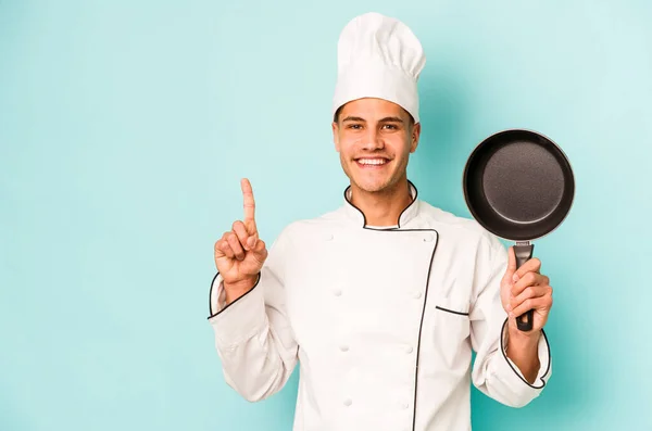 Young Caucasian Chef Man Holding Flying Pan Isolated Blue Background — Stock Photo, Image