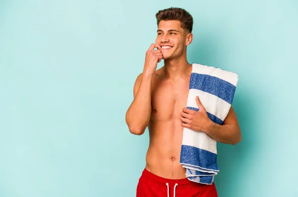 Young Caucasian Man Holding Beach Towel Isolated Blue Background Relaxed — Stock fotografie
