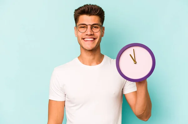 Young Caucasian Man Holding Clock Isolated Blue Background Happy Smiling — Stock Fotó