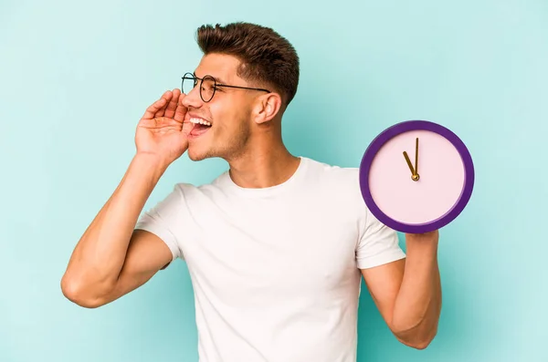 Young Caucasian Man Holding Clock Isolated Blue Background Shouting Holding — Photo