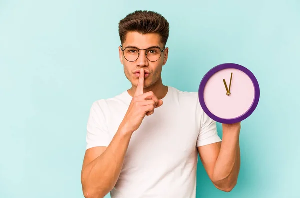 Young Caucasian Man Holding Clock Isolated Blue Background Keeping Secret — Photo