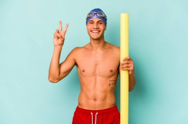 Mavi arka planda köpük çubuğu tutan beyaz yüzücü iki numarayı parmaklarıyla gösteriyor..