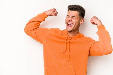 Beyaz arka planda izole edilmiş genç beyaz bir adam zaferden sonra yumruğunu kaldırıyor, kazanan konsept.