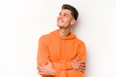 Beyaz arka planda izole edilmiş genç beyaz adam hedeflere ve amaçlara ulaşmayı hayal ediyor.