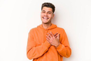 Beyaz arka planda izole edilmiş beyaz tenli genç bir adam, dostane bir ifadeye sahip, avuçlarını göğsüne bastırıyor. Aşk konsepti.