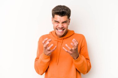Beyaz arka planda izole edilmiş genç beyaz adam gergin elleriyle çığlık atıyor..