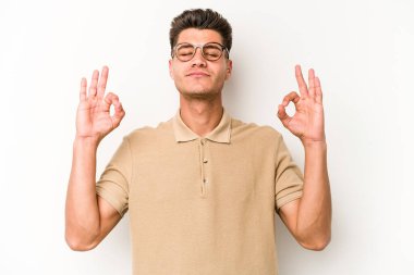 Beyaz arka planda izole edilmiş genç beyaz adam yoğun bir günün ardından rahatlıyor. Yoga yapıyor..