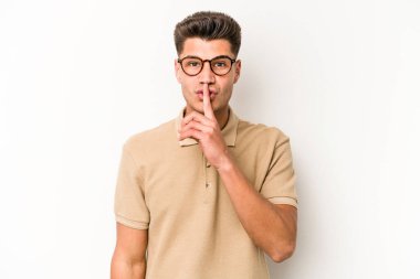 Beyaz arka planda izole edilmiş genç beyaz bir adam ya sır saklıyor ya da sessizlik istiyor..